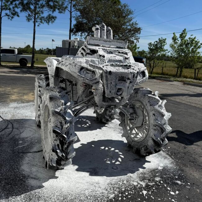 Lifted Polaris ATV covered in foam suds during a snow foam wash in Southwest Florida