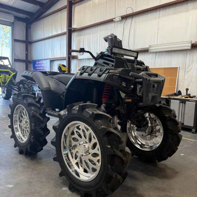 Black lifted Polaris ATV with polished chrome wheels and mud tires after detailing in Southwest Florida