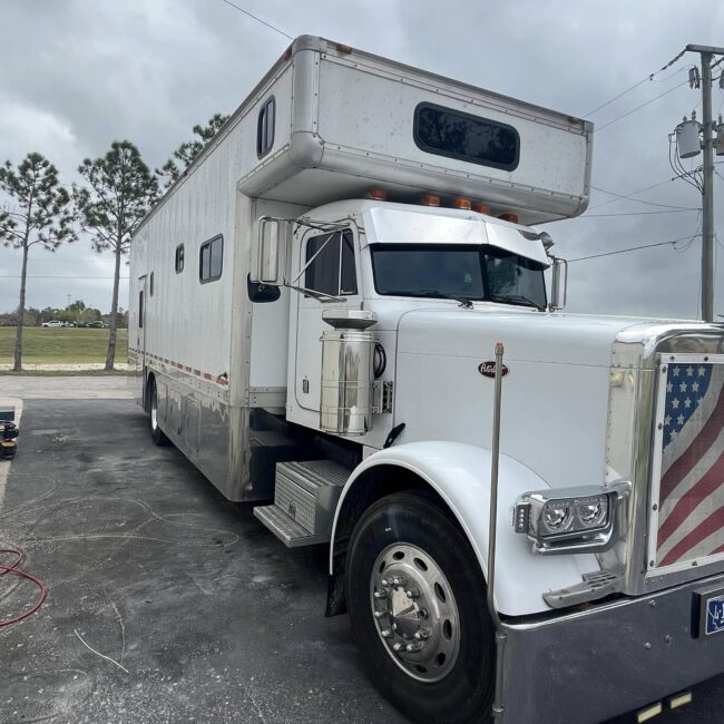 White Peterbilt RV toterhome parked before a full detail at a Southwest Florida detailing shop